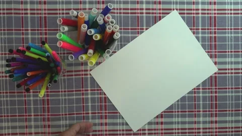 Concept. White paper on a table with checkered fabric, preparing to draw. Stock Footage 130571677