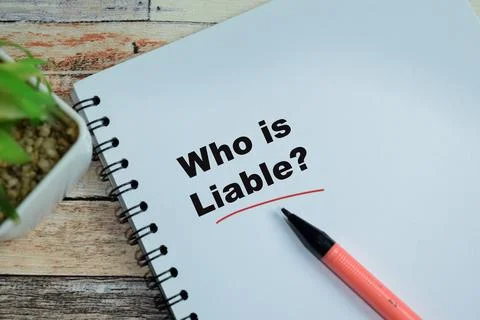 Concept of who is liable write on book isolated on Wooden Table Stock Photos
