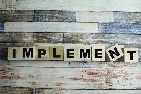 Concept of The wooden Cubes with the word Implement on wooden background. Foto stock