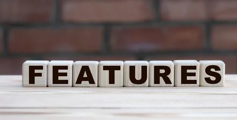 Concept word FEATURES on cubes against the background of a brick wall Stock Photos