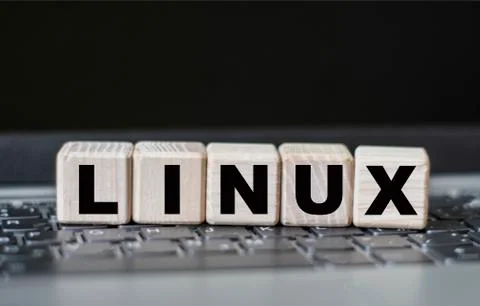 Concept word LINUX on cubes on the background of a laptop Stock Photos