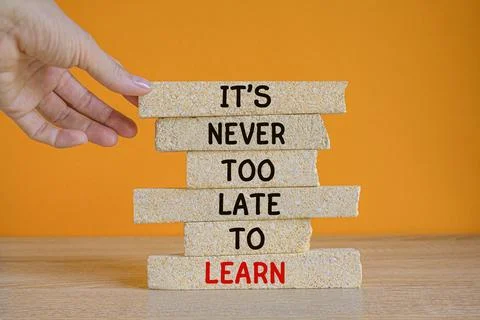 Concept words 'It is never too late to learn on brick blocks. Stock Photos