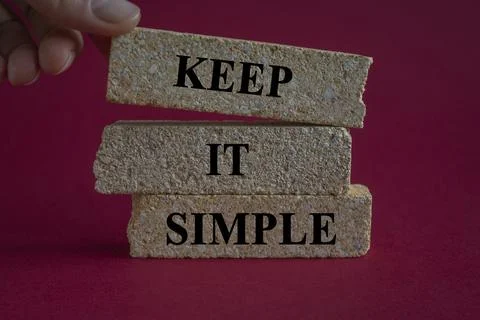 Concept words Keep it Simple on brick blocks. Beautiful red background Stock Photos