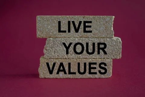 Concept words Live your values on brick blocks. Beautiful pink background. Stock Photos
