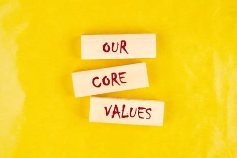 Concept words OUR CORE VALUES symbol on wooden blocks on a yellow background 写真素材