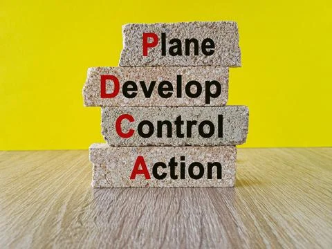 Concept words PDCA, plan develop control action on brick blocks Foto stock