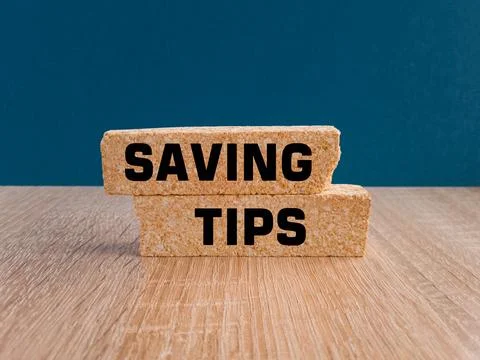 Concept words Saving Tips on brick blocks. Beautiful wooden table Stock-Fotos