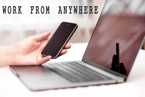 The concept work from anywhere. Computer and hand with phone on desktop  Foto stock