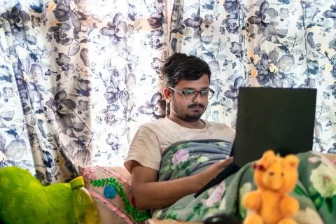 Concept of working from home. Middle-Class Asian Male leaning against the win Stock Photos