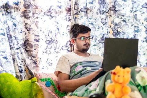 Concept of working from home. Middle-Class Asian Male leaning against the win Stock Photos