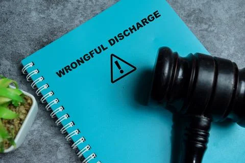 Concept of wrongful discharge write on book isolated on Wooden Table. 스톡 사진