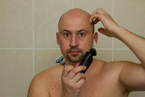 Concept. The young man chooses what he shave electric razor or hand razor Stock Photos