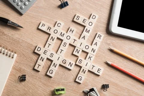 Conceptual business keywords on table with elements of game making crossword 库存照片