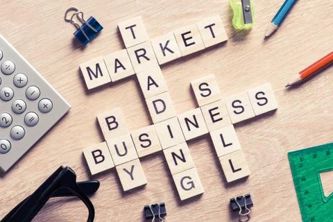 Conceptual business keywords on table with elements of game making crossword 库存照片