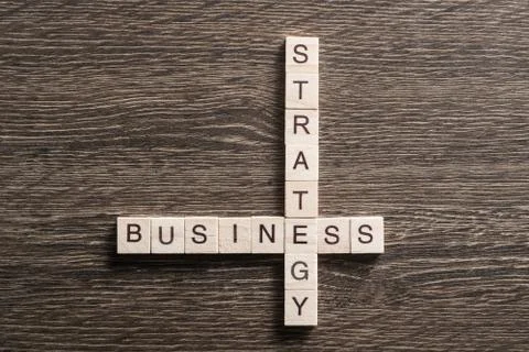 Conceptual business keywords on table with elements of game making crossword 库存照片