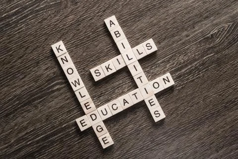 Conceptual business keywords on table with elements of game making crossword 库存照片