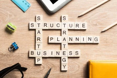 Conceptual business keywords on table with elements of game making crossword 库存照片