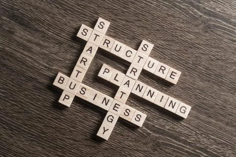 Conceptual business keywords on table with elements of game making crossword 库存照片