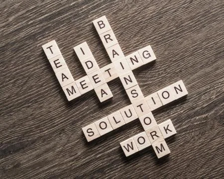 Conceptual business keywords on table with elements of game making crossword 库存照片