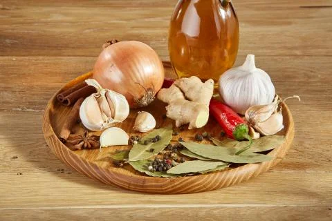 Conceptual composition of different spices and oil bottle on a wooden tray on Stock Photos