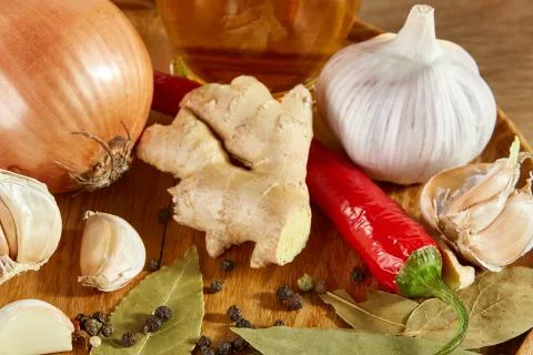 Conceptual composition of different spices and oil bottle on a wooden tray on Stock Photos