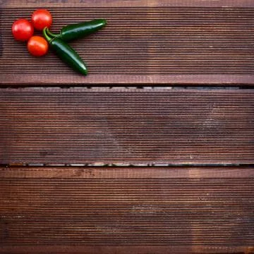 A conceptual composition of red cherry tomatoes and hot green chili peppers o 스톡 사진