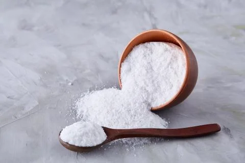 Conceptual composition of salt and pepper on spoons and bowls over light Stock Photos