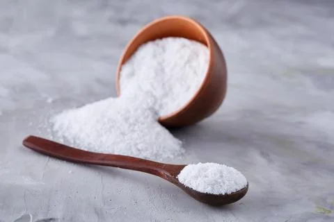 Conceptual composition of salt and pepper on spoons and bowls over light Stock Photos