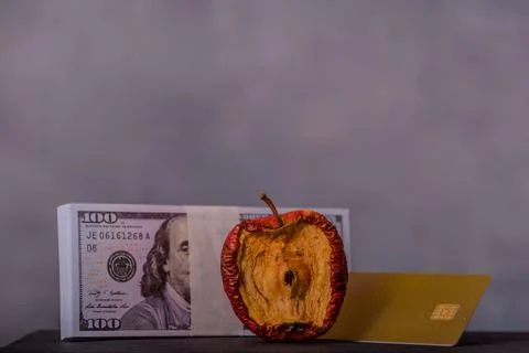A conceptual image centered on a bad apple, money and credit card for various Stock Photos
