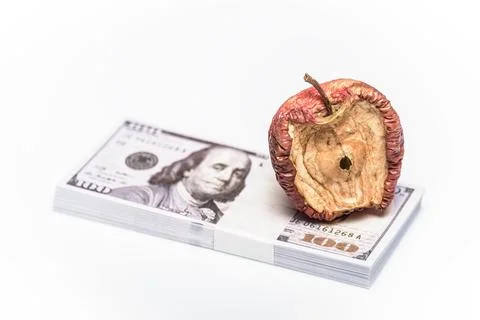 A conceptual image centered on a bad apple, money for various monetary ideas. Stock Photos