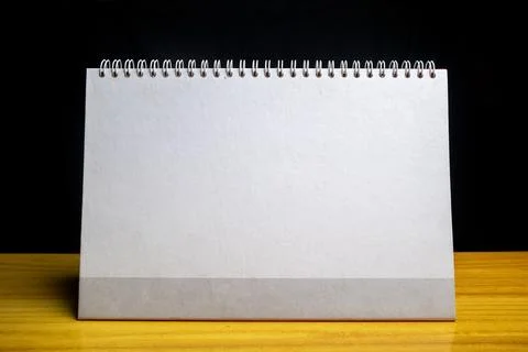 A conceptual image featuring a blank desk calendar with a white spiral bind.. Stock Photos