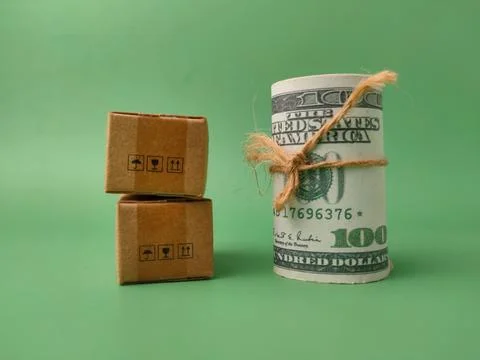Conceptual image featuring a roll of US dollar bills tied with twine next t.. Stock Photos