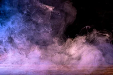 Conceptual image of multi-colored smoke isolated on dark black background and Foto stock