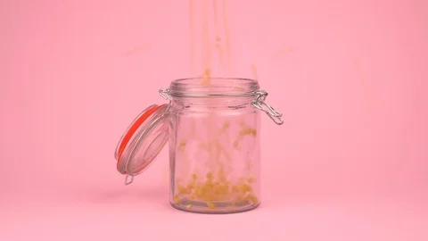 Conceptual image of popcorn falling on jar glass over pastel background. Stock Footage 106805757