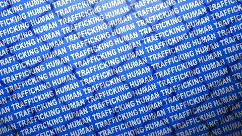 Conceptual image representing human trafficking, featuring repeated text on.. Stock Photos