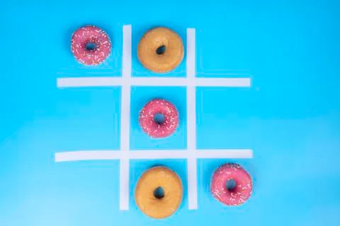 Conceptual image, three in a row of glazed donuts on blue background Stock Photos