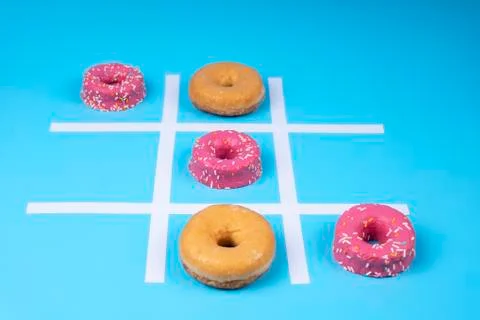 Conceptual image, three in a row of glazed donuts on blue background. Stock Photos