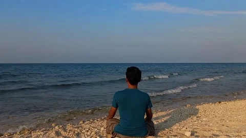 Conceptual man sitting alone in the beach Stock Footage 235788220