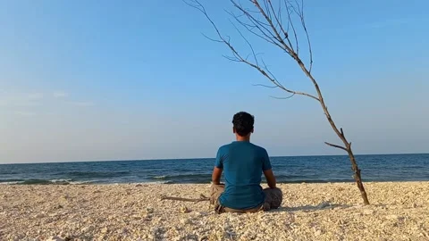 Conceptual man sitting alone in the beach Stock Footage 235789644