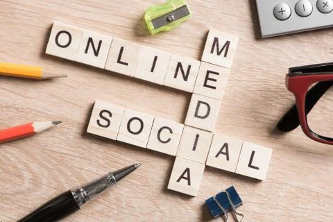 Conceptual media keywords on table with elements of game making crossword Foto stock