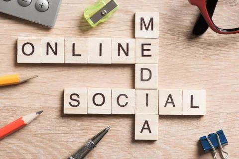 Conceptual media keywords on table with elements of game making crossword Stock Photos