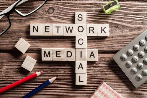 Conceptual media keywords on table with elements of game making crossword Stock Photos