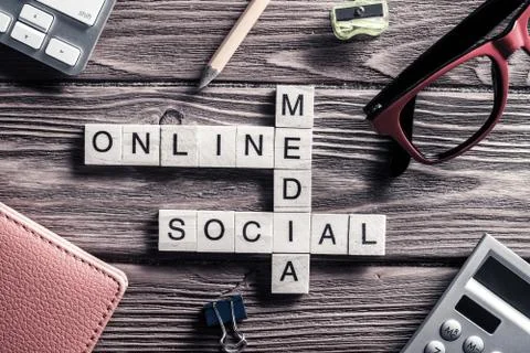 Conceptual media keywords on table with elements of game making crossword Stock Photos