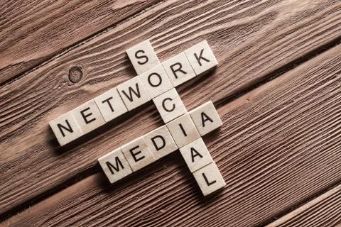 Conceptual media keywords on table with elements of game making crossword Stock Photos