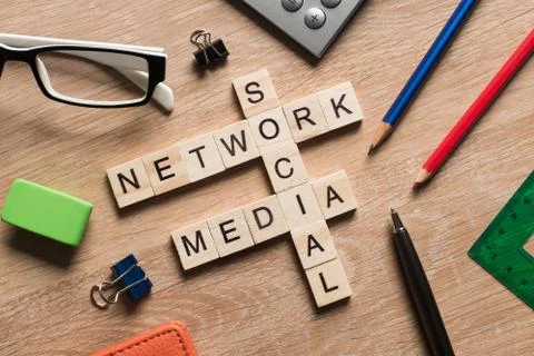 Conceptual media keywords on table with elements of game making crossword Stock Photos