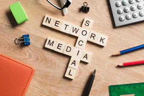 Conceptual media keywords on table with elements of game making crossword Stock Photos