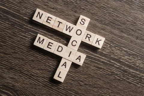 Conceptual media keywords on table with elements of game making crossword Stock Photos