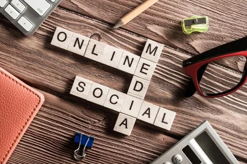 Conceptual media keywords on table with elements of game making crossword Stock Photos