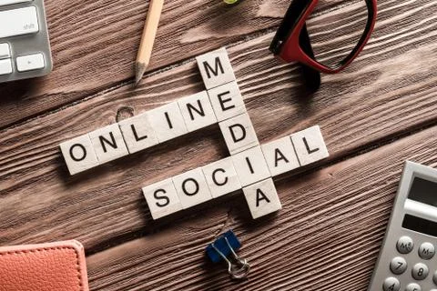 Conceptual media keywords on table with elements of game making crossword Stock Photos