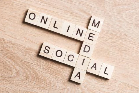 Conceptual media keywords on table with elements of game making crossword Stock Photos